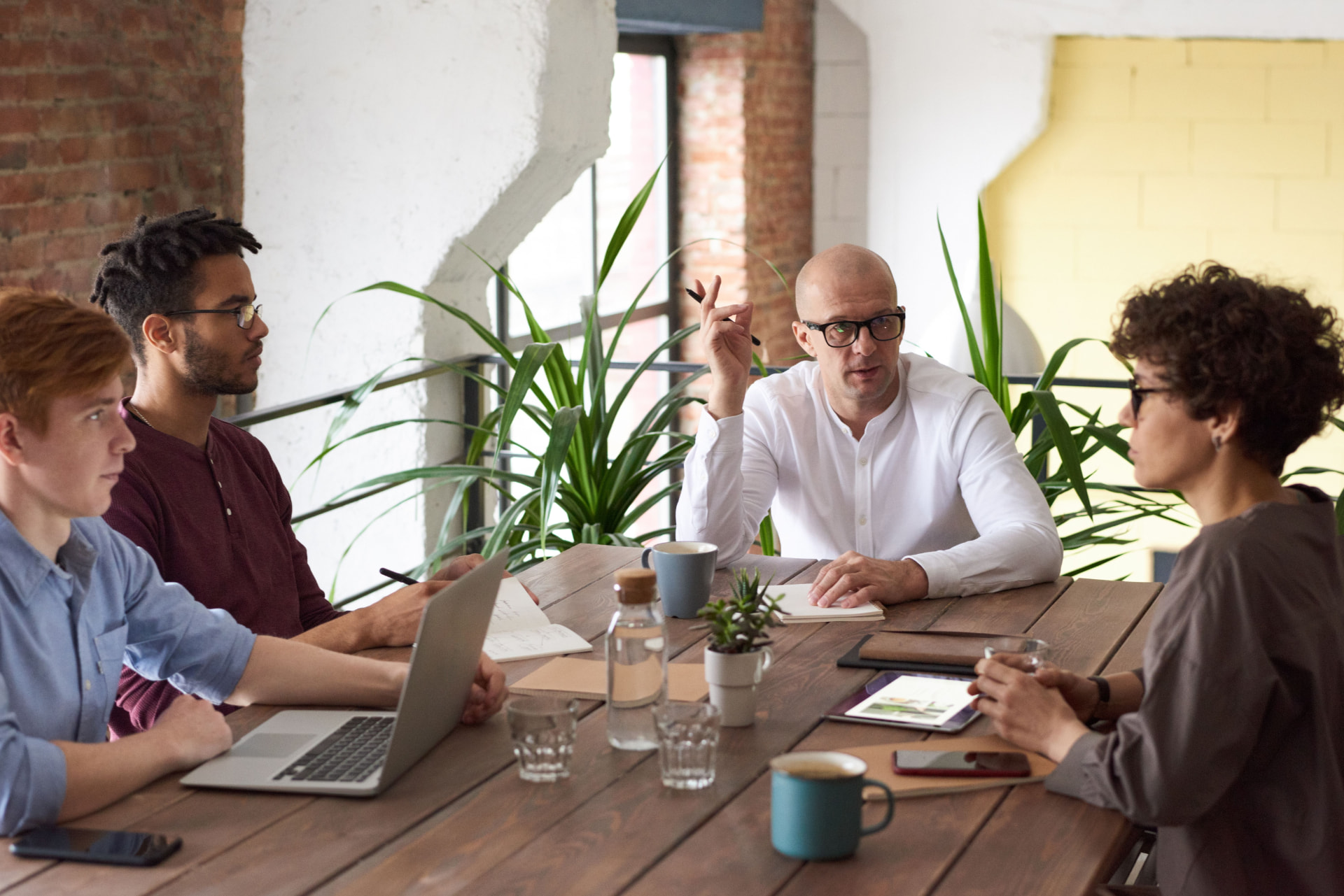 Diverse team collaborating around a wooden table in a bright modern workspace